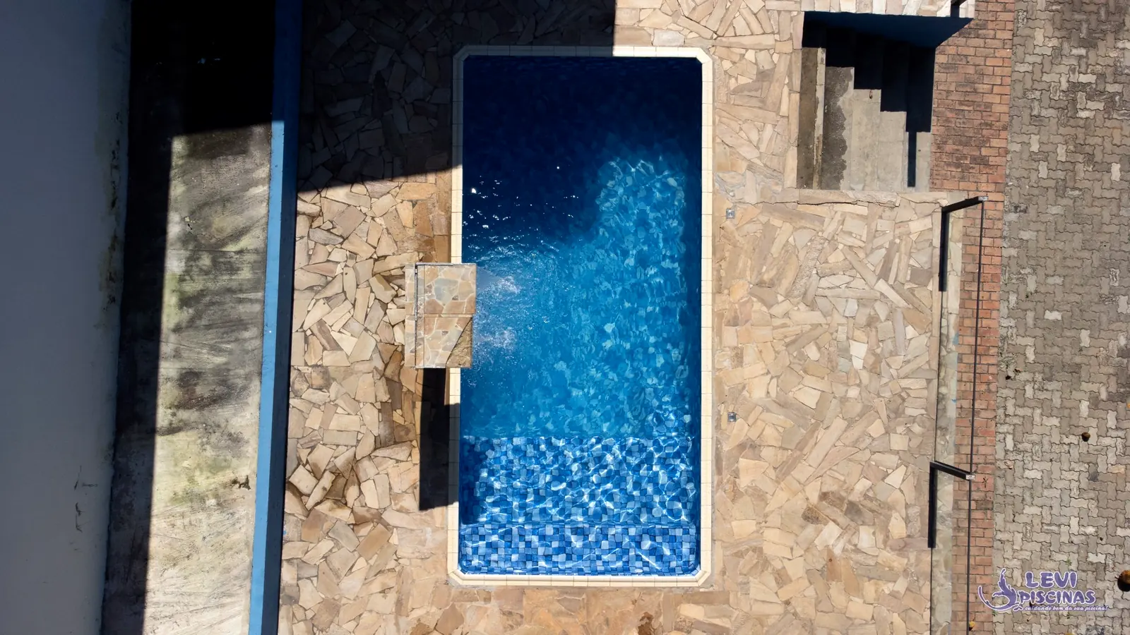 Piscina compacta residencial com cascata, construída pela Levi Piscinas