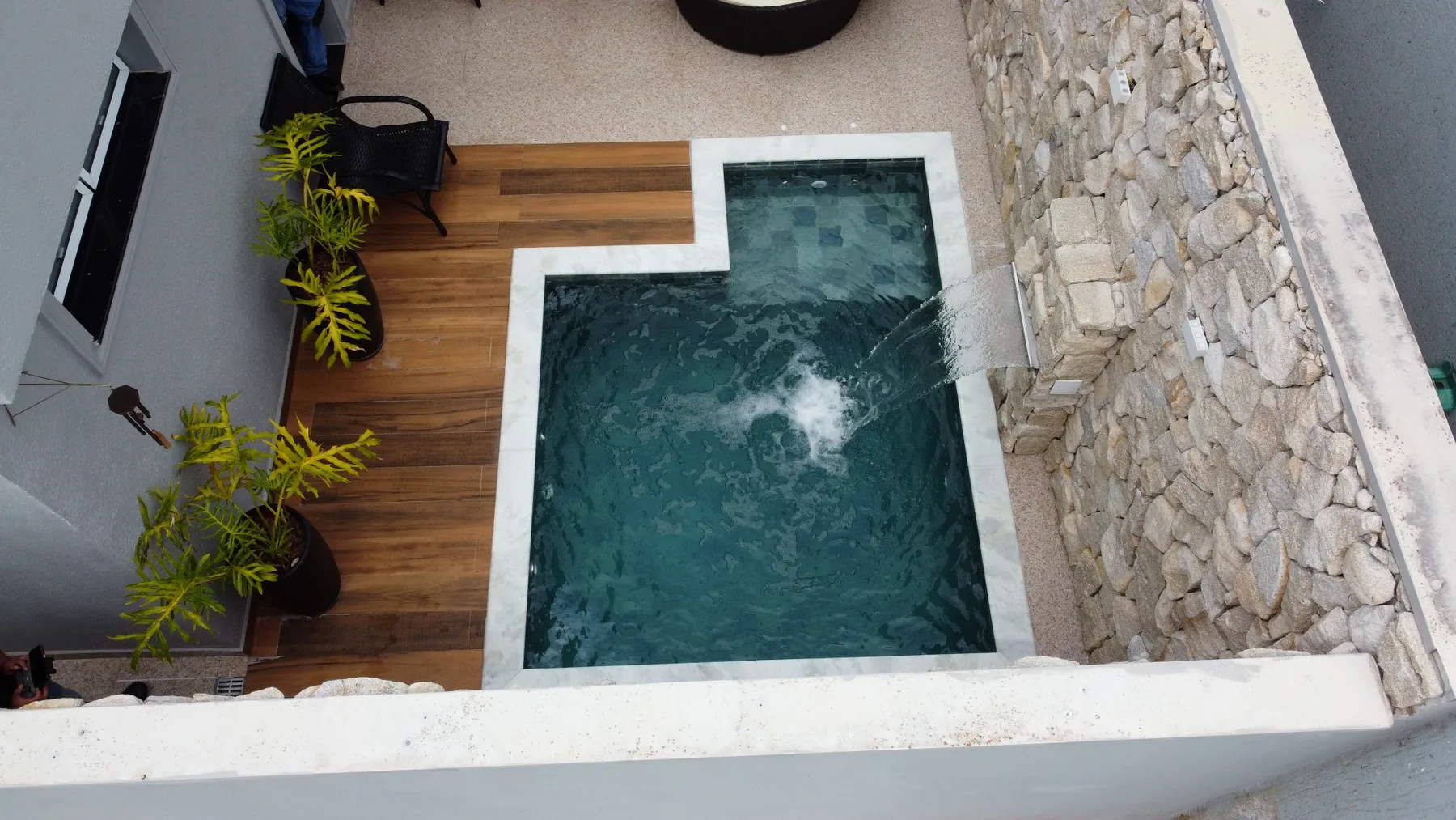 Piscina para família com cascata, paisagismo e acabamento em pedra em Itapetininga