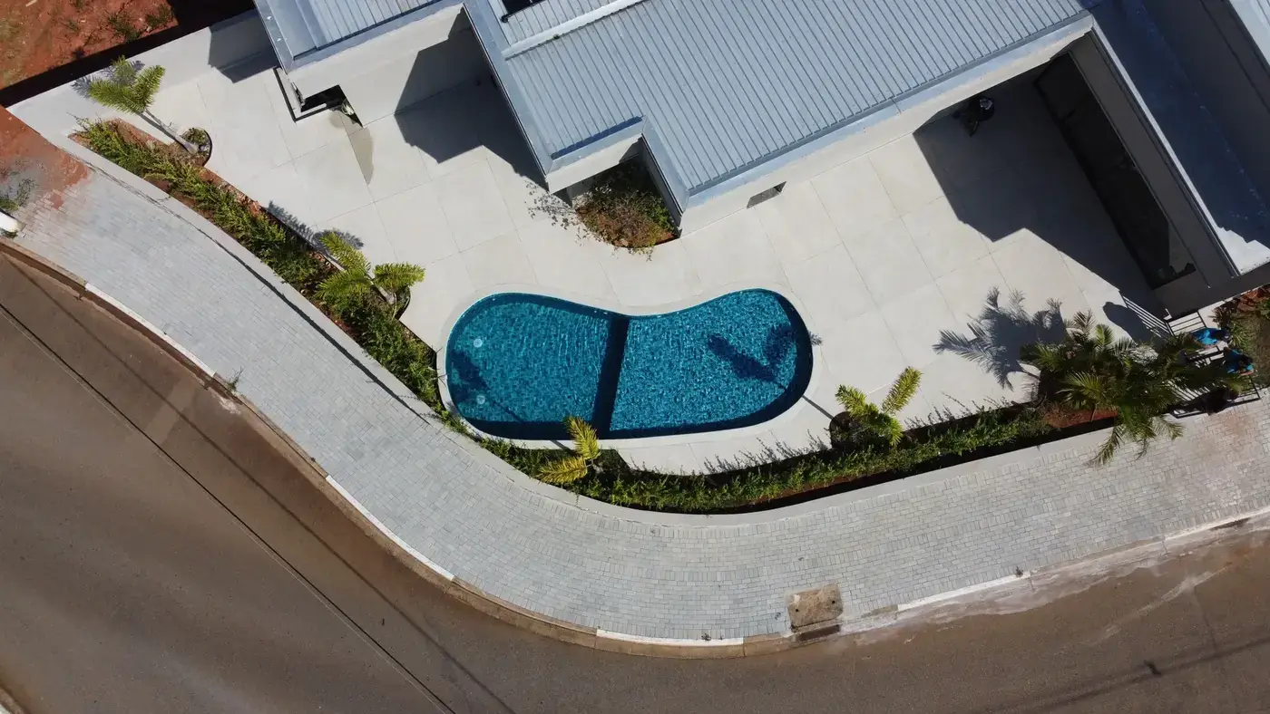 Piscina residencial de formato orgânico com paisagismo